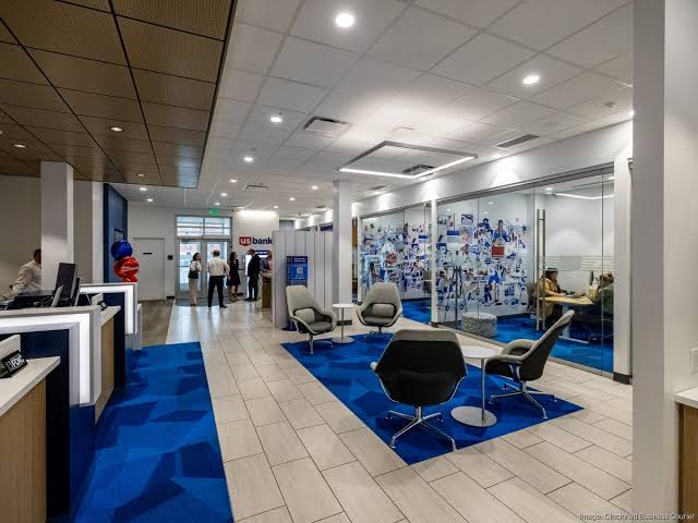 Open US Bank branch floor plan showing modern seating area with blue geometric carpet and glass-walled meeting rooms